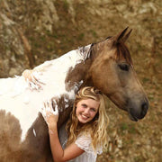 A picture of a smiling woman giving her horse a bath using WashBar Horse and Hound bar soap